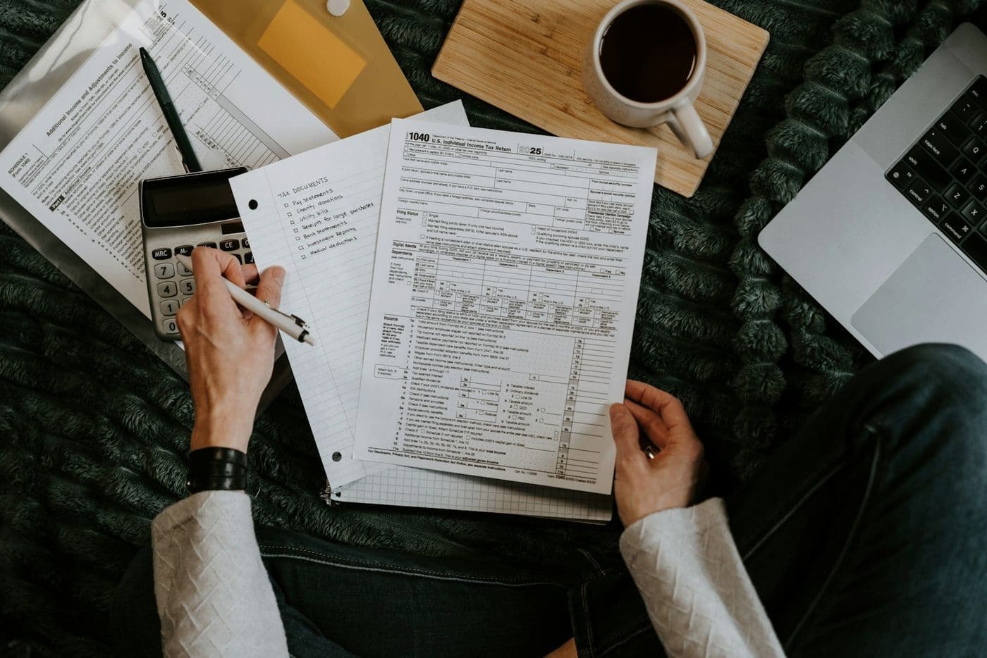 Hands reviewing printed financial documents with a calculator