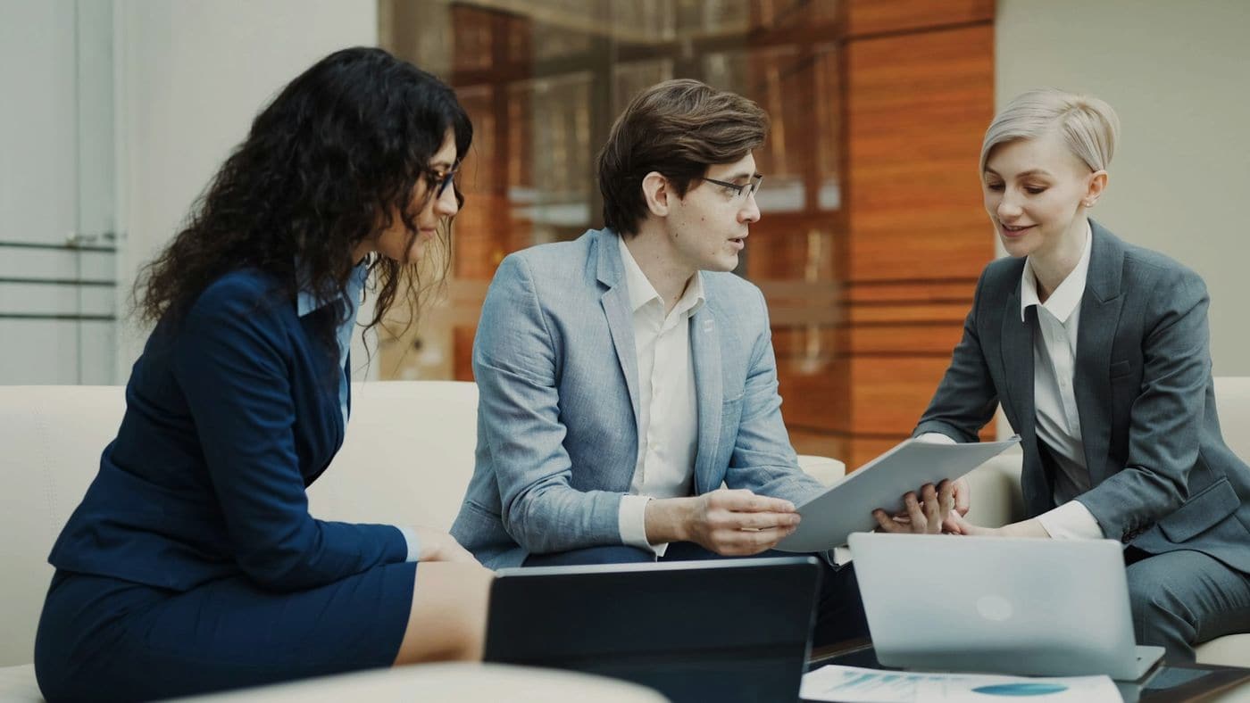Three professionals reviewing documents together
