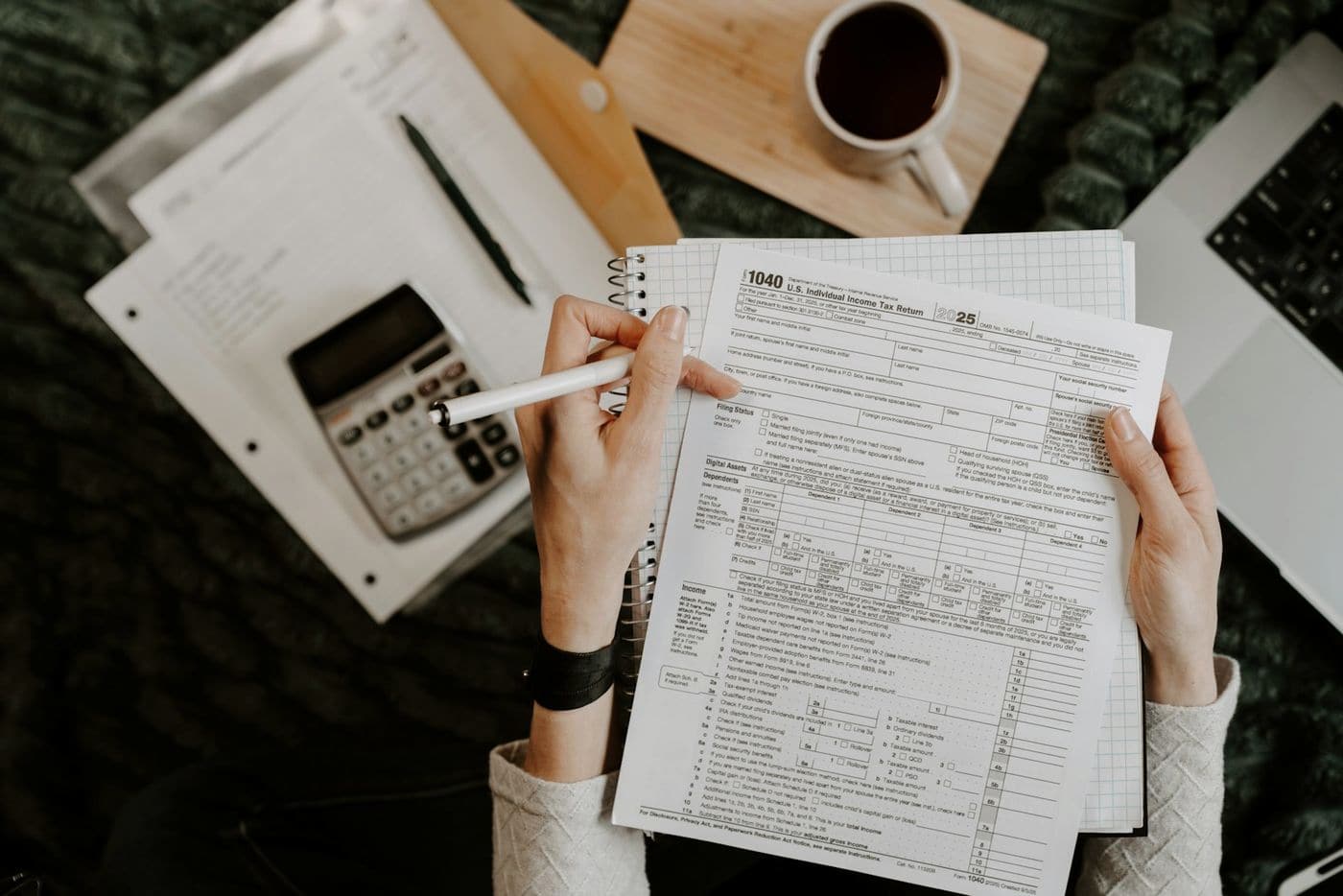 Hands reviewing printed financial documents next to a calculator